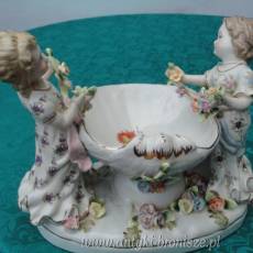 Puchar z porcelany (polichromia) w formie muszli podtrzymywanej przez 2 dziewczynki. (apocryphe). H 18 x 22cm - poz. 5142