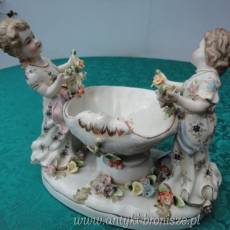 Puchar z porcelany (polichromia) w formie muszli podtrzymywanej przez 2 dziewczynki. (apocryphe). H 18 x 22cm - poz. 5142